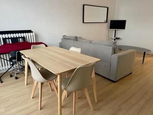 un salon avec une table en bois et un canapé dans l'établissement Fabuleux et charmant appartement idéal en famille, à Drancy