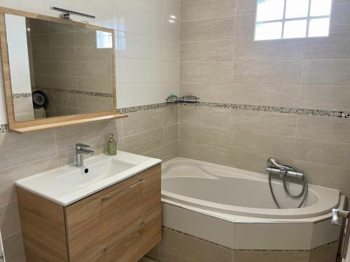 une salle de bain avec une baignoire et un lavabo dans l'établissement Fabuleux et charmant appartement idéal en famille, à Drancy