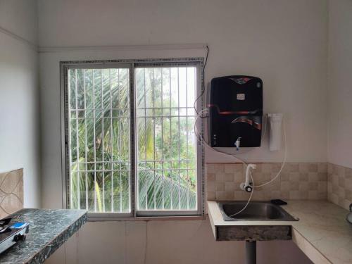 une cuisine avec un évier et une fenêtre dans l'établissement Panchalaya Homestay, à Guwahati