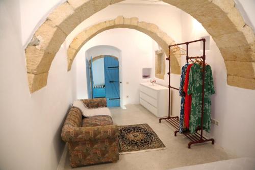 a living room with a couch and a blue door at Traditional house in Mitata next to the canyon! in Kýthira