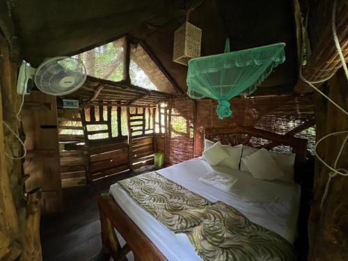a bedroom with a bed in a room with windows at SAYON RIVER COTTAGE & ECO GARDEN in Monaragala