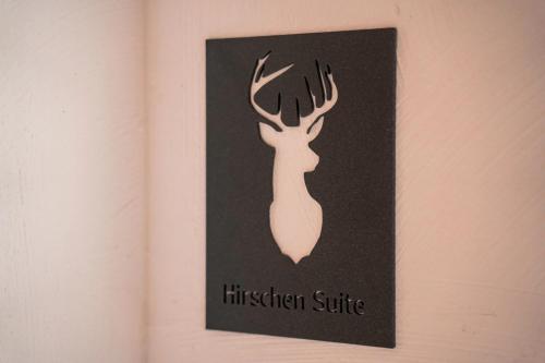 a black sign with a picture of a deer on a wall at Chalet WildRuh in Ried im Zillertal
