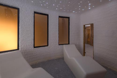 a bathroom with three mirrors and a white couch at Luxury Glamping Beach Villas Porto Bus in Bale