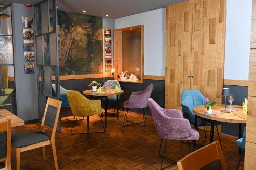 a restaurant with tables and chairs and a painting on the wall at Hotel Kiekenstein in Stahle