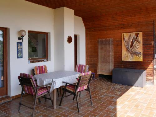 eine Terrasse mit einem Tisch und Stühlen sowie einem Gemälde in der Unterkunft Ferienwohnung Lahr in Lahr