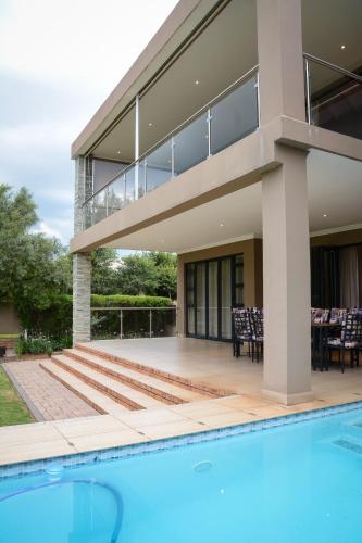 a house with a swimming pool in front of a house at Kingfisher on Vaal, Parys in Parys
