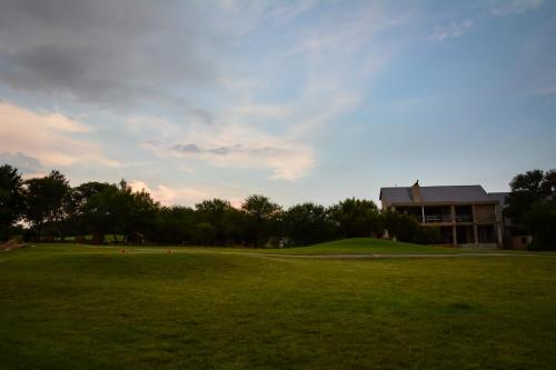 a green field with a building in the background at Kingfisher on Vaal, Parys in Parys