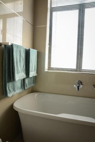 a white bath tub in a bathroom with blue towels at Kingfisher on Vaal, Parys in Parys