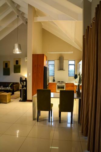 a kitchen and living room with a table and chairs at Kingfisher on Vaal, Parys in Parys