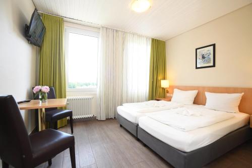 a hotel room with a bed and a desk and a window at Hotel Kiekenstein in Stahle