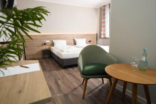 a room with a bed and a chair and a table at Hotel Kiekenstein in Stahle