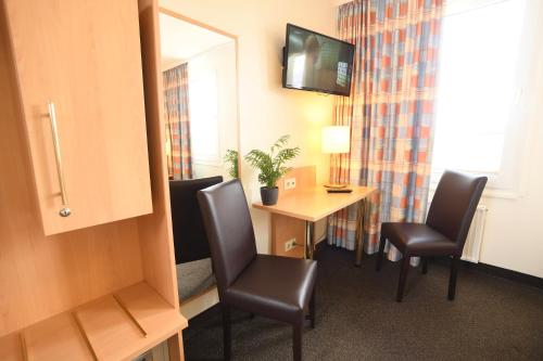 a room with a desk and chairs and a mirror at Hotel Kiekenstein in Stahle