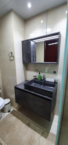 a bathroom with a black sink and a toilet at Spacious Villa with terrace close to the sea in Ras al Khaimah