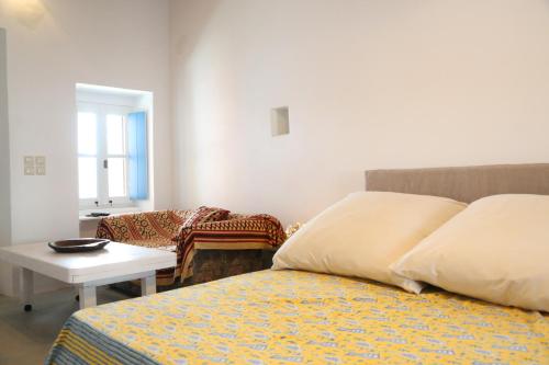 a bedroom with a bed and a table and a couch at Traditional house in Mitata next to the canyon! in Kýthira