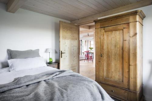 a bedroom with a bed and a wooden door at Urgemütliche Reetdachkate mit großem Kamin und Sauna in Pommerby