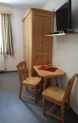 a room with a table and two chairs and a television at Biobauernhof Habersatter in Radstadt