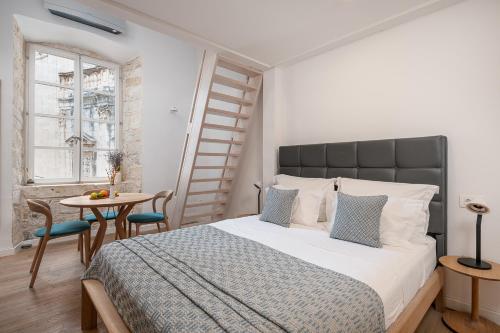 a bedroom with a bed and a table with chairs at Clouds Boutique Guesthouse in Dubrovnik