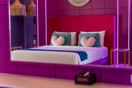 a pink bedroom with a bed with hearts on the pillows at LOVE beach club Koh Samui in Chaweng