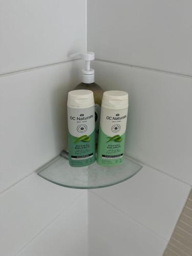 two deodorant bottles sitting on a shelf in a bathroom at Tranquil 2-bedroom retreat in Lake Albert