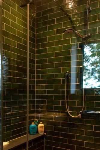 a bathroom with a shower in a brick wall at The Kennels in Hexham