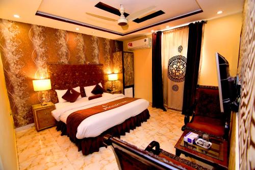 ein Schlafzimmer mit einem großen Bett und einem TV. in der Unterkunft Premier Inn Gulberg Lahore in Lahore