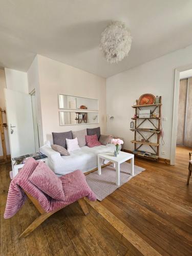 un salon avec un canapé blanc et une table dans l'établissement La marmotte, à Barcelonnette