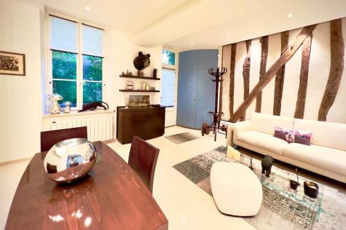 a living room with a table and a couch at Saint Germain en Laye Hyper Centre Apartment 2 min RER in Saint-Germain-en-Laye