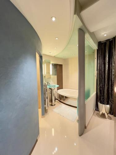 a large bathroom with a tub and a sink at Saint Germain en Laye Hyper Centre Apartment 2 min RER in Saint-Germain-en-Laye
