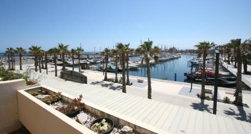 - une vue sur un port de plaisance avec des palmiers et des bateaux dans l'établissement Studio avec vue paradisiaque sur port et mer, au Barcarès
