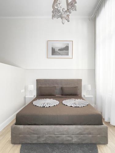 a bedroom with a large bed in a white room at Trigon Palace in Budapest