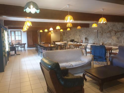 un restaurant avec un canapé, des tables et des chaises dans l'établissement Chambres d'hôtes ancienne fermette Aubrac, à Prinsuéjols
