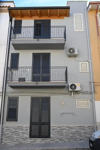 an apartment building with a balcony and a fan at AL Quadrifoglio in Terrasini