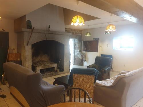 - un salon avec une cheminée, un canapé et des chaises dans l'établissement Chambres d'hôtes ancienne fermette Aubrac, à Prinsuéjols