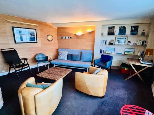 - un salon avec deux chaises, un canapé et une table dans l'établissement Appartement Vue Mer, à Trouville-sur-Mer