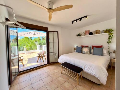 アギラスにあるChalet con Piscina Privada - La Cálidaのベッドルーム1室(ベッド1台付)、スライド式ガラスドアが備わります。