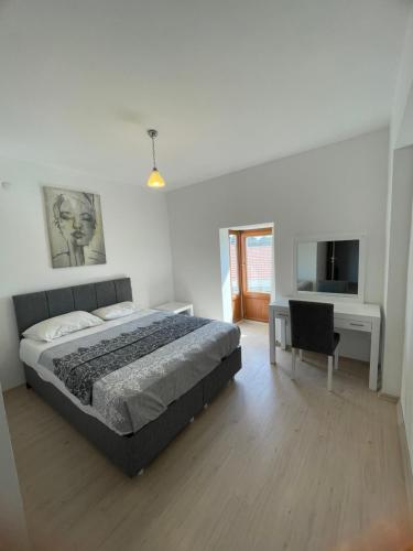 a bedroom with a bed and a desk and a television at Çeşme Suites in Çeşme