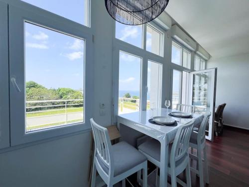 une salle à manger avec une table, des chaises et des fenêtres dans l'établissement Appart avec vue mer incroyable sur l'Aber Wrac'h, à Landéda