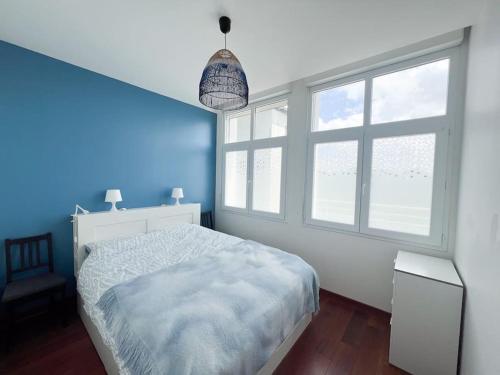 - une chambre bleue avec un lit et 2 fenêtres dans l'établissement Appart avec vue mer incroyable sur l'Aber Wrac'h, à Landéda