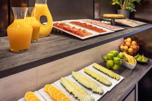 a buffet with many different types of food and orange juice at B&B HOTEL Ciudad de Lleida in Lleida