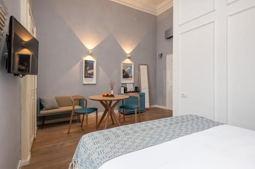 a bedroom with a bed and a table and chairs at Clouds Boutique Guesthouse in Dubrovnik