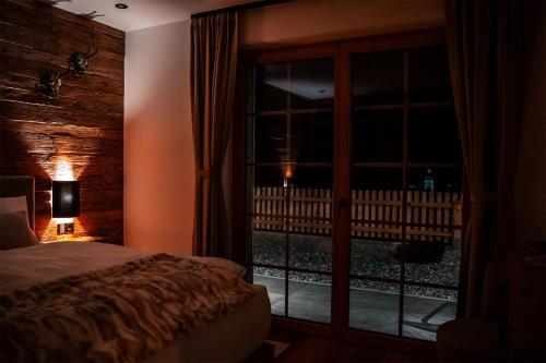 a bedroom with a bed and a window at night at Chalet WildRuh in Ried im Zillertal