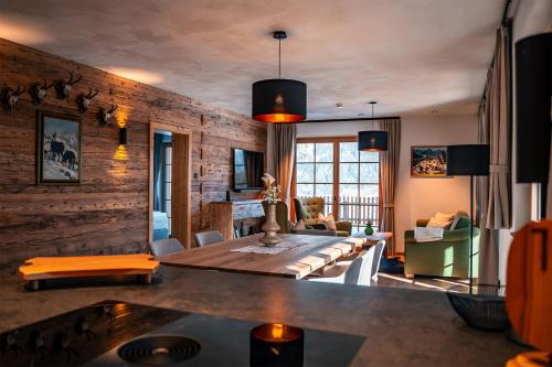 a dining room with a table and a living room at Chalet WildRuh in Ried im Zillertal