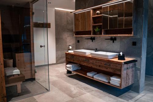 a bathroom with two sinks and a glass shower at Chalet WildRuh in Ried im Zillertal