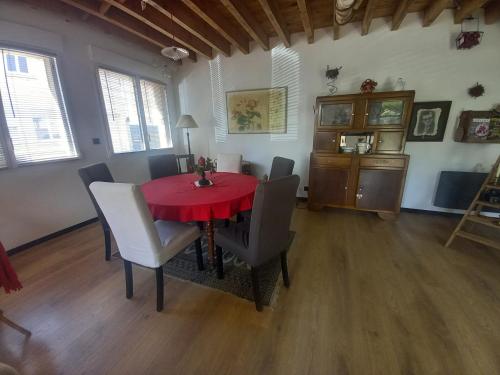 une salle à manger avec une table et des chaises rouges dans l'établissement La maison Jardin, à Fougères