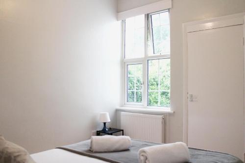 une chambre avec un lit et une fenêtre dans l'établissement Large Garden Apartment on Golders Green High Road, à Londres