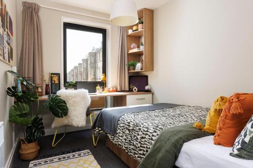 a bedroom with a bed and a desk and a window at Unite Students - Chalmers Street - The Meadows in Edinburgh