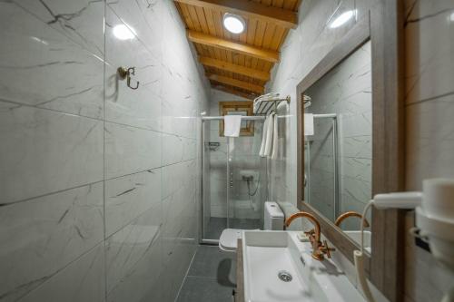 a white bathroom with a sink and a shower at Alfa Suites & SPA in Sapanca