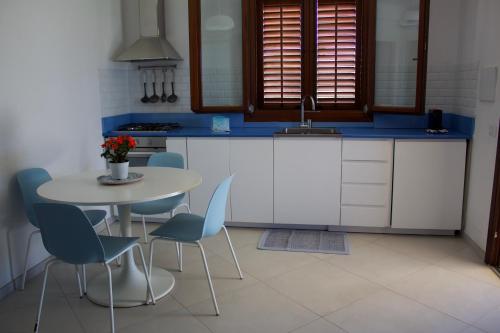 a kitchen with a table and chairs and a sink at Le Casette a Favignana in Favignana