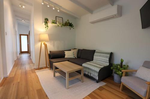 a living room with a couch and a table at Satin Bower Cottage in Eagle Heights