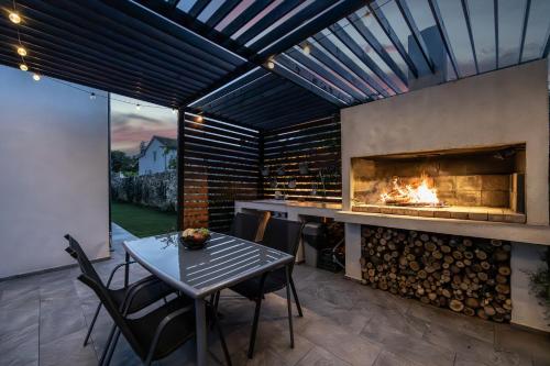 eine Terrasse mit einem Kamin, einem Tisch und Stühlen in der Unterkunft Villa Kali near Pula for 8 people with fitness & sea view - pet friendly in Krnica